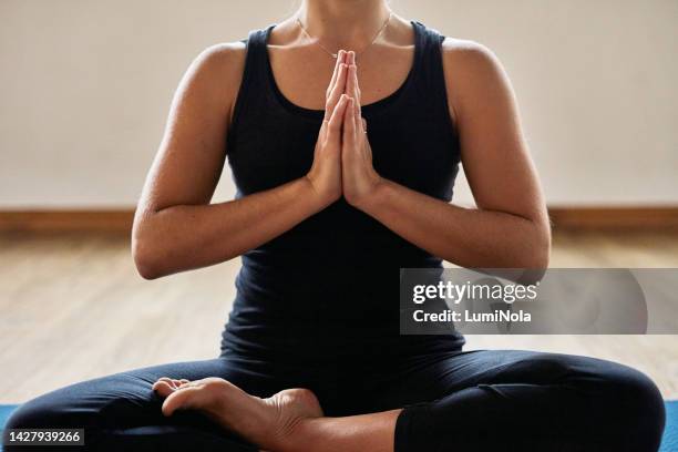 yoga, pilates and zen woman in a lotus pose training body posture, mindfulness and peace in a calm studio or house. wellness, fitness and relaxed person in meditation sitting in a easy position - namaste stock pictures, royalty-free photos & images