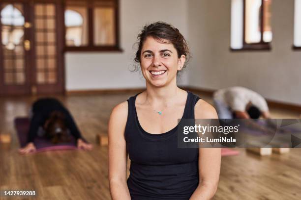 mujer, yoga y coach en estudio zen, clase de pilates y estiramientos para el bienestar, entrenamiento de salud y energía de chakras. retrato de la persona de la sonrisa, feliz y la paz en la sala de relajación, meditación y entrenamiento mental - yogi fotografías e imágenes de stock