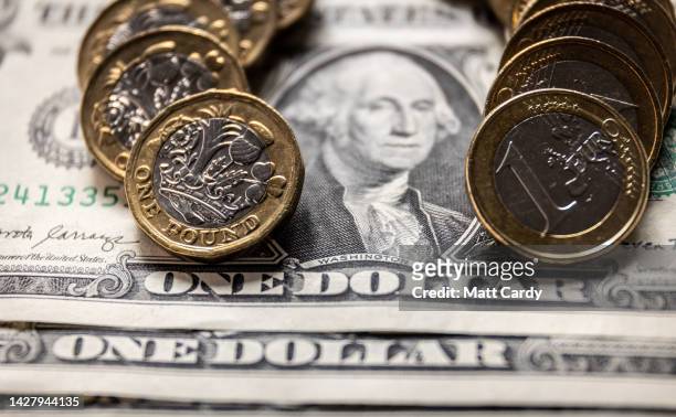 In this photo illustration, U.S. Dollar bills are are pictured with British GDP £1 coin and a one Euro coin on September 27, 2022 in Bath, England....