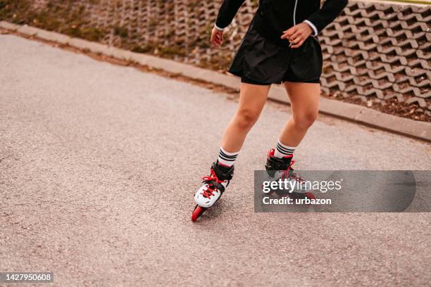 young woman roller skating down the street - running shorts stock pictures, royalty-free photos & images