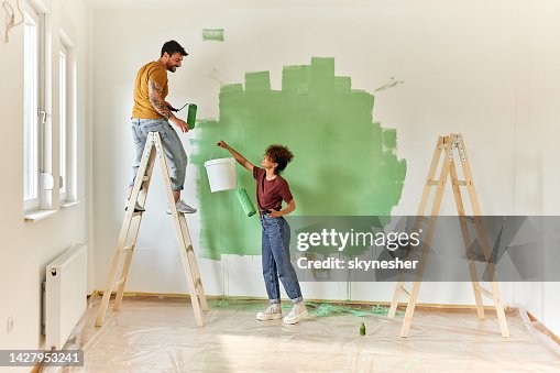 Happy couple painting their new apartment. Happy couple painting their new apartment.