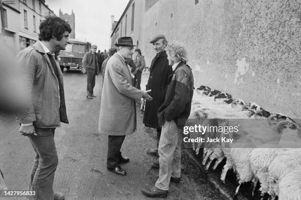 British politician Enoch Powell offers his hand in a handshake as he speaks with local residents while campaigning for the Ulster Unionist Party for...