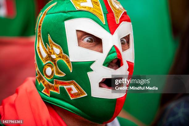 mexican sport fan wearing wrestling mask screaming and celebrating goal during international football championship match - wrestler stock pictures, royalty-free photos & images