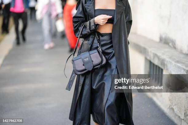 Guest wears a black shoulder-off / cropped top, a black shiny leather long coat, a black shiny leather handbag from Prada, a black long skirt,...