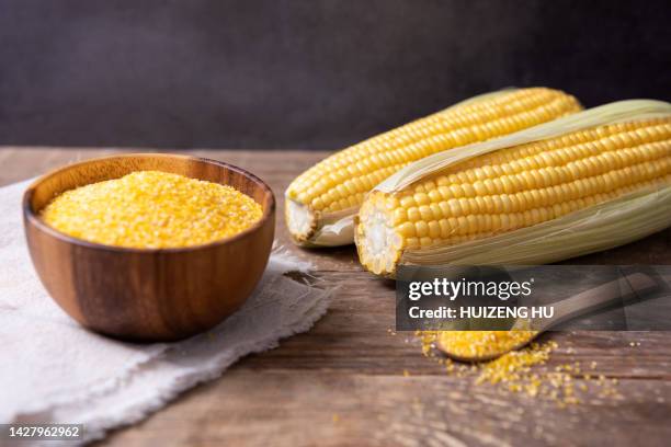 corn grits in bowl and fresh corn on table - farinha de milho imagens e fotografias de stock