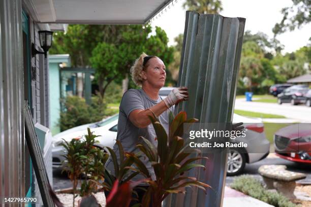 Rebecca Hale places shutters on her home as she prepares for the possible arrival of Hurricane Ian on September 27, 2022 in St Petersburg, Florida....