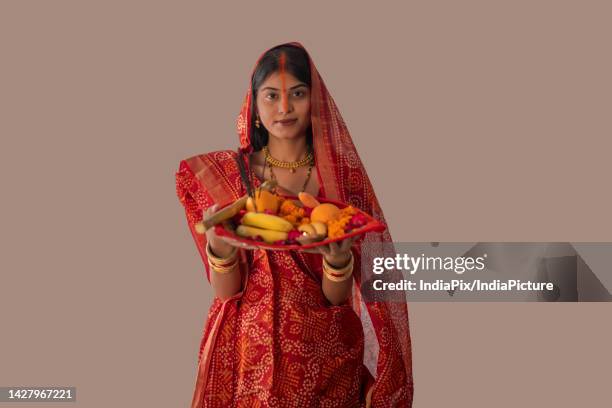 woman from bihar offers prayers to the sun in the early morning hours during chhath puja festival - chhath festival stock pictures, royalty-free photos & images