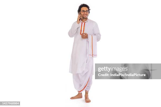 portrait of bengali man talking on mobile phone against white background - kurta stock pictures, royalty-free photos & images