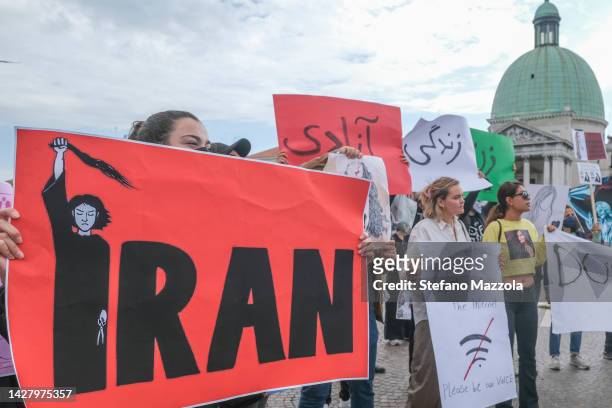Iranian girls protest in front of Venice train station displaying signs on September 27, 2022 in Venice, Italy. Iranian Democrats have gathered to...