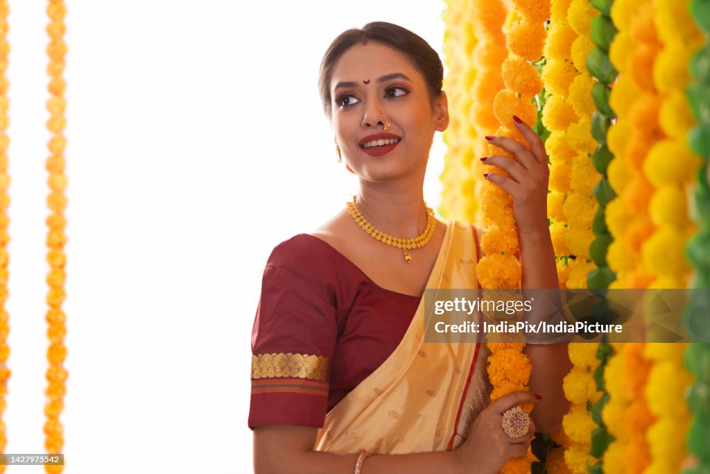 Maharashtrian woman decorating with flower garlands on festival