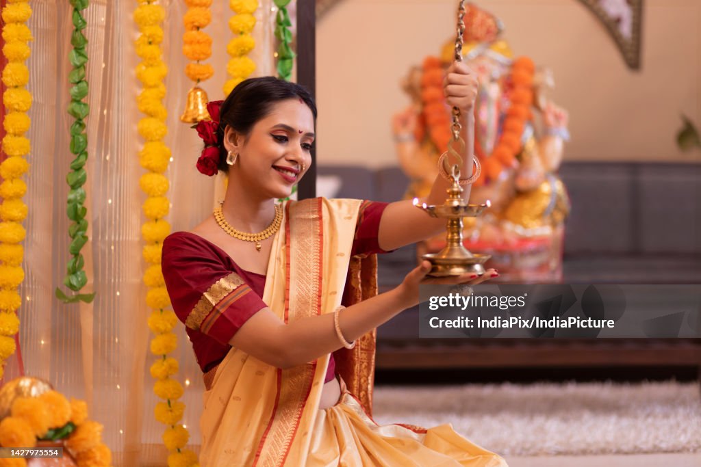 Portrait of Maharashtrian woman in traditional dress holding oil lamp on the occasion of Ganesh Chaturthi