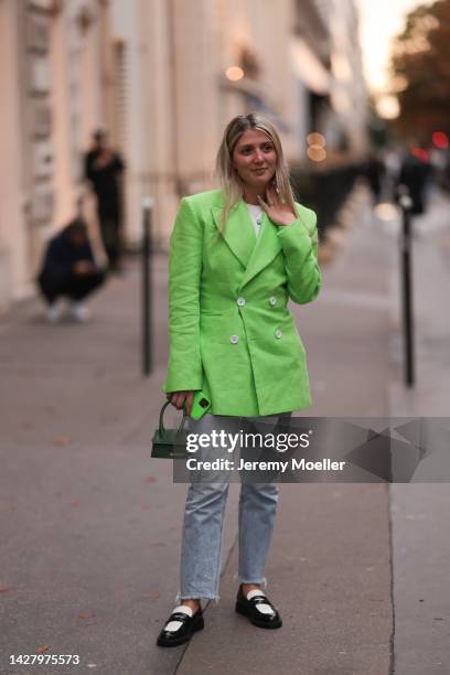 Fashion week guest seen wearing a Jacquemus green neon blazer and bag, outside Jacquemus store opening during fashion week in Paris on September 26,...