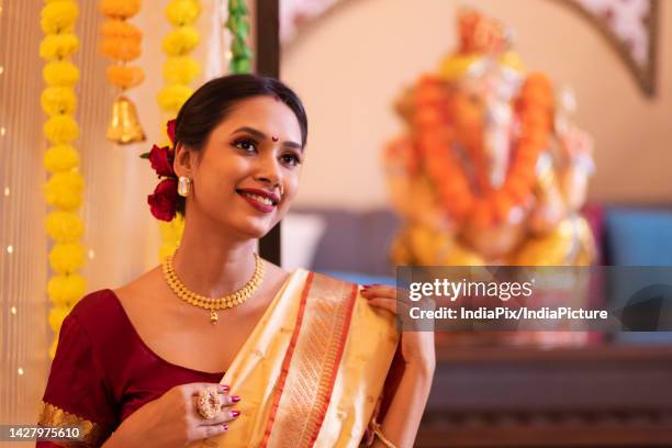 portrait of a cheerful maharashtrian woman in traditional dress looking elsewhere on the occasion of ganesh chaturthi - ganesh chaturthi stock pictures, royalty-free photos & images