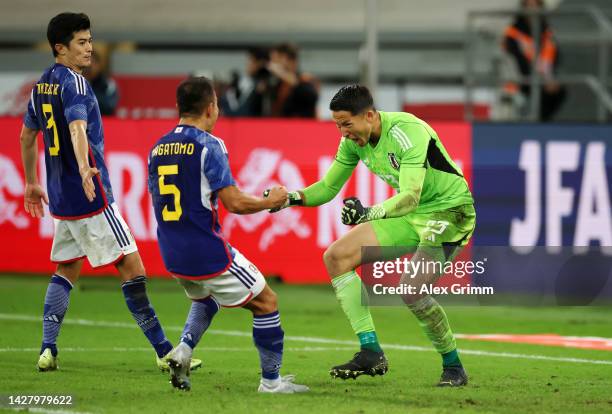 Daniel Schmidt of Japan celebrates with teammates Yuto Nagatomo and Shogo Taniguchi after saving a penalty shot from Enner Valencia of Ecuador during...