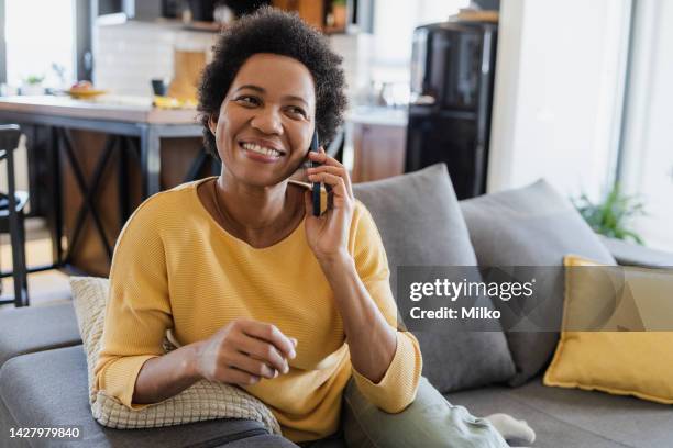 femme adulte parlant au téléphone à la maison - utiliser un téléphone photos et images de collection