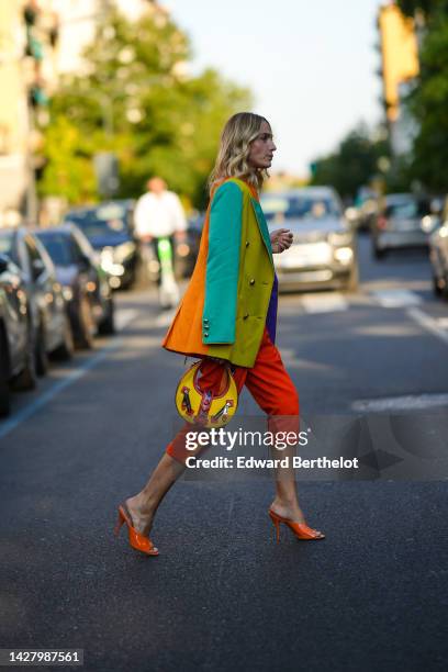 Guest wears a multicolored striped print pattern blazer jacket from Moschino, orange and red striped print pattern denim short pants from Moschino, a...