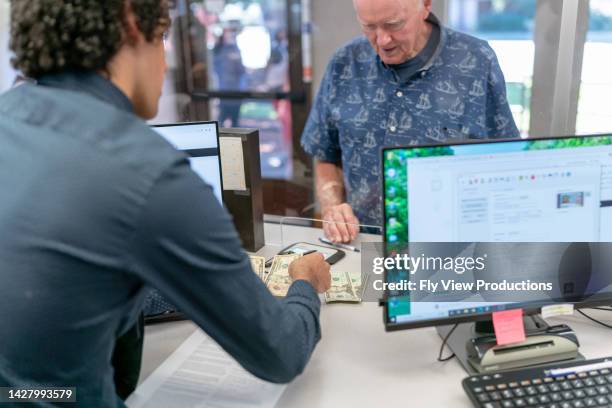 bank teller counting money for customer - bank office clerks stock pictures, royalty-free photos & images