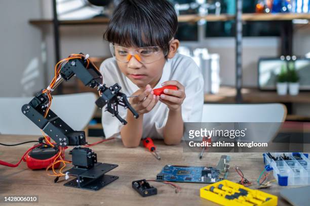 a smart kid inventor of robot arm. - student inventor stock pictures, royalty-free photos & images