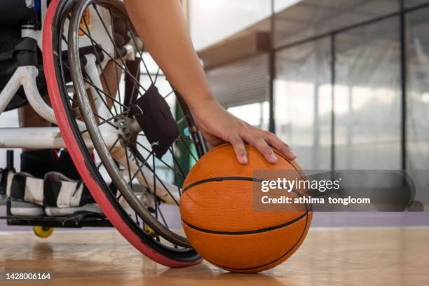 hand of a wheelchair basketball player with a basketball in the gym. - paraplegic stock pictures, royalty-free photos & images