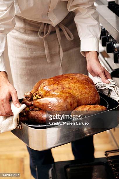 man lifting cooked turkey out of oven - christmas table turkey ストックフォトと画像