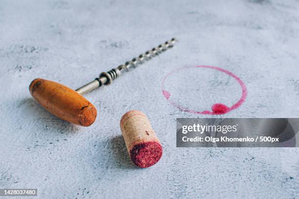 vintage corkscrew,cork and red wine stain over gray background - corkscrew foto e immagini stock