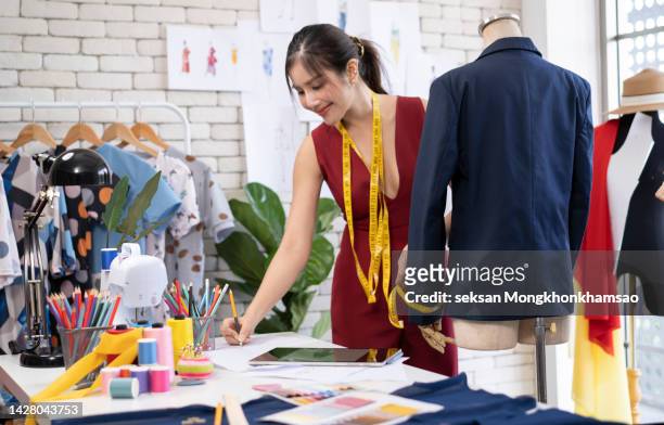 young fashion designer working in her atelier - modedesigner stock-fotos und bilder
