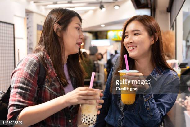 two happy asian women enjoy bubble milk tea at night market - taipei tea stock pictures, royalty-free photos & images