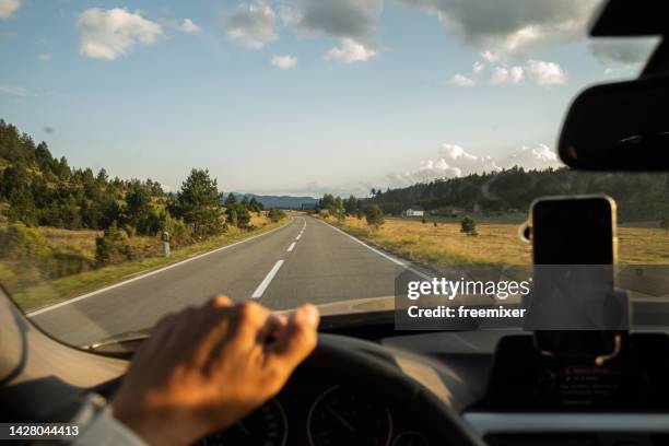 hombre conduciendo por una hermosa carretera - parabrisas fotografías e imágenes de stock