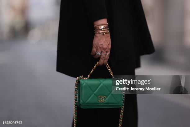 Martina Maturi is seen wearing black wool sweater and pants from Genesis, green leather Chanel bag, gold Cartier Love, Cartier Juste Un Clou and...