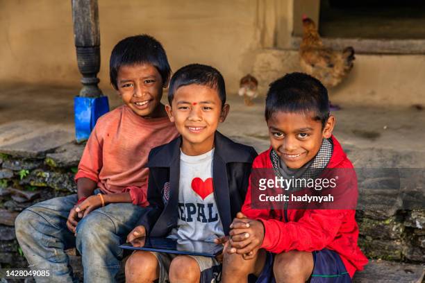 nepali children using digital tablet near annapurna range - nepal child stock pictures, royalty-free photos & images