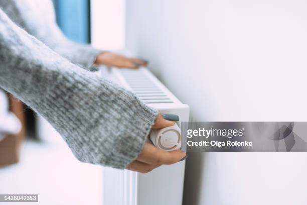 economic crisis and despair in cold houses. control thermostat temperature on radiator - ホット ストックフォトと画像