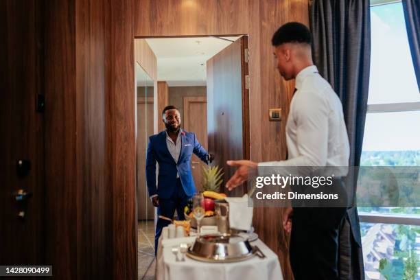 waiter with luxurious room service at hotel room. - serviço de quarto imagens e fotografias de stock