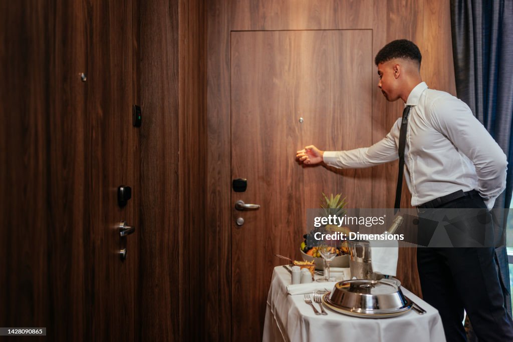 Kellner klopft an die Tür der Hotelzimmergäste.