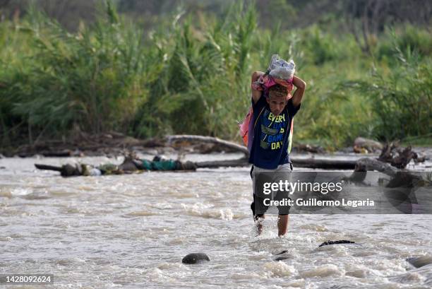 Person crosses the Tachira River with a sack on his shoulders from Venezuela to Colombia on an illegal border by-path a day after a commercial border...