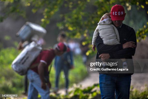 Person carries a little kid through an illegal border by-path to cross from Venezuela to Colombia a day after a commercial border reopening between...