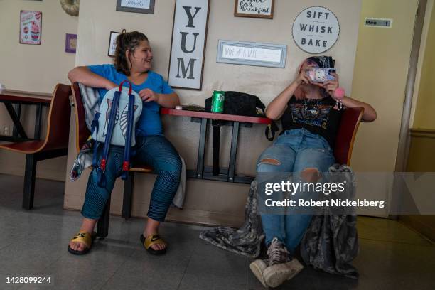 Two young women sit in the 3 Little Cupcakes bakery and restaurant August 27, 2022 in Welch, West Virginia. Welch is the county seat of McDowell...