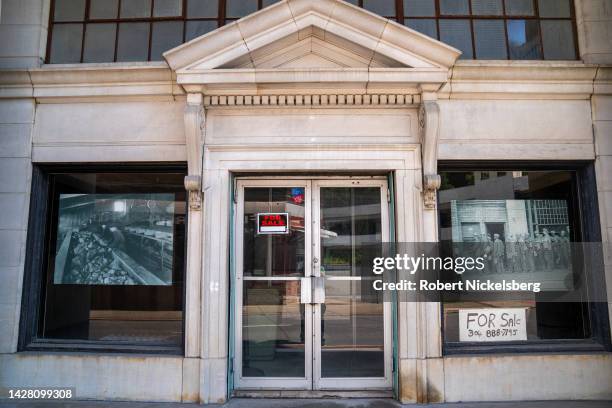 Historic black and white photographs of coal miners hang in an abandoned bank building August 27, 2022 in Welch, West Virginia. The abandoned bank...