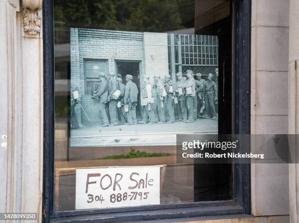 Historic black and white photograph of coal miners hangs in an abandoned bank building August 27, 2022 in Welch, West Virginia. The abandoned bank...