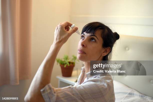 woman in her room using eye drops - eye drop stock pictures, royalty-free photos & images