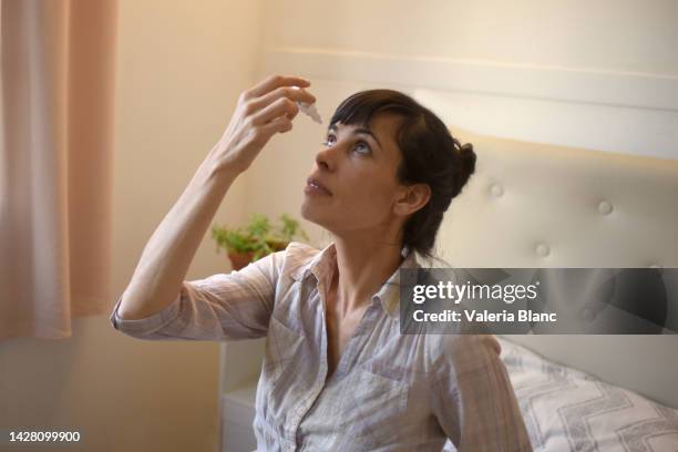 woman in her room using eye drops - eyedropper stock pictures, royalty-free photos & images