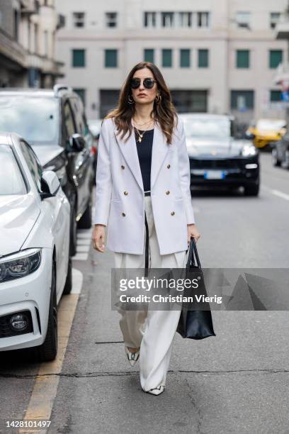 Maria Kokhia wears white Maria Kokhia suit , black large Dior bag, YSL pointed heels outside during the Milan Fashion Week - Womenswear Spring/Summer...