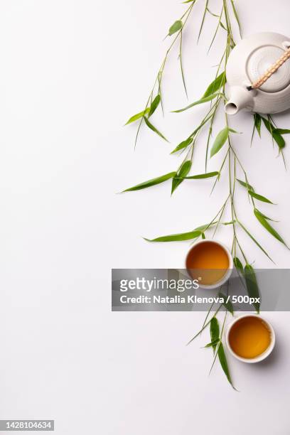 asian food background set with green tea,cups and teapot with bamboo branches - tesil bildbanksfoton och bilder