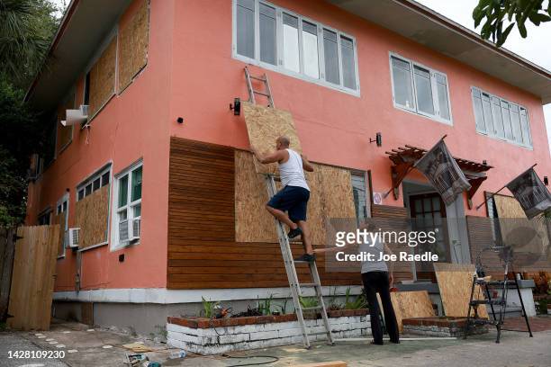Edward Montgomery and Courtney Viezux board up Montgomery's apartment building as they prepare for the possible arrival of Hurricane Ian on September...
