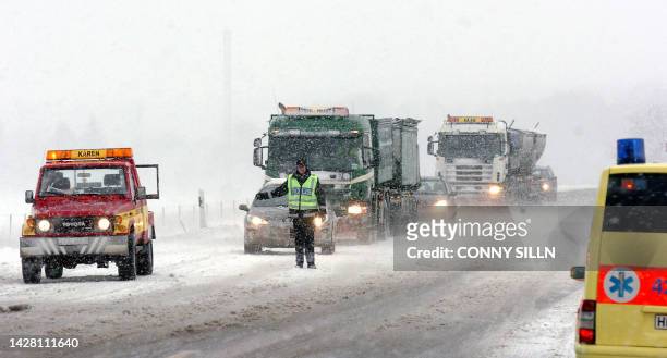 Frozen policeman is standing on the snowy road E20 for traffic directing after a traffic accident outside Swedish town Arboga, 150 km west of...