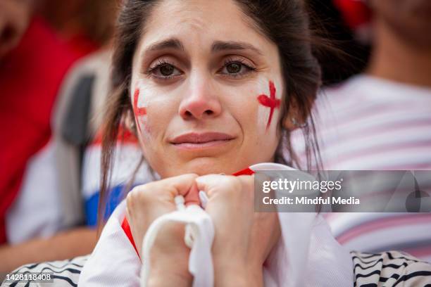sad english football supporter holds english flag in both hands frustrated after national team fails to win international game - u20 sports competition stockfoto's en -beelden