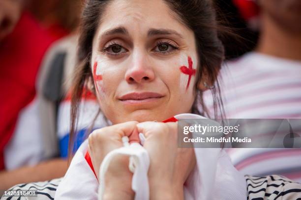 sad english football supporter holds english flag in both hands frustrated after national team fails to win international game - england fans stock pictures, royalty-free photos & images