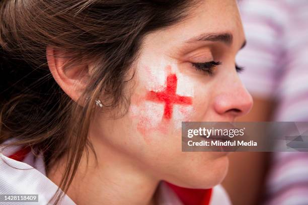 sad english woman with white and red face paint frustrated after england national team fails to win game - national flag stock pictures, royalty-free photos & images