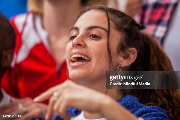 happy young football fan chanting and cheering for favorite team in crowded stands during football match - leigh french 個照片及圖片檔