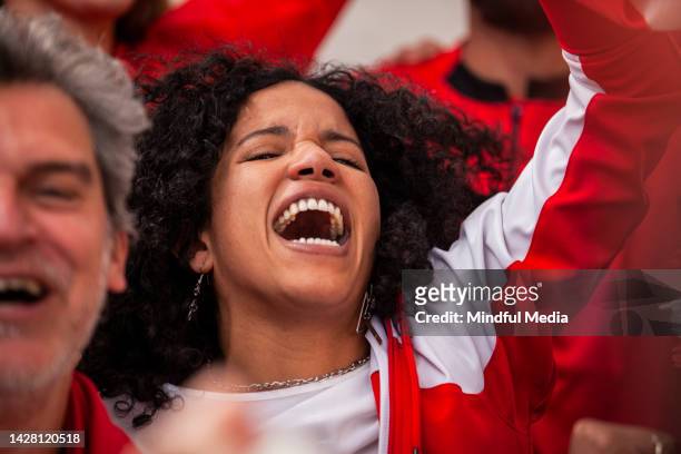 euphorischer fußballfan, der während des nationalmannschaftsspiels auf überfüllten tribünen mit erhobenem arm singt und jubelt - stadium stands stock-fotos und bilder