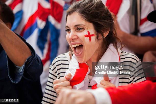 giovane tifosa di calcio inglese felice che indossa la bandiera inglese al collo cantando in una partita della squadra nazionale - england u20 football foto e immagini stock